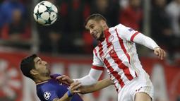 Striker Barcelona, Luis Suarez, duel udara dengan bek Olympiakos, Omar Elabdellaoui, pada laga Liga Champions di Stadion Karaiskakis, Selasa (31/10/2017). Barcelona bermain imbang 0-0 dengan Olympiakos. (AP/Thanassis Stavrakis)