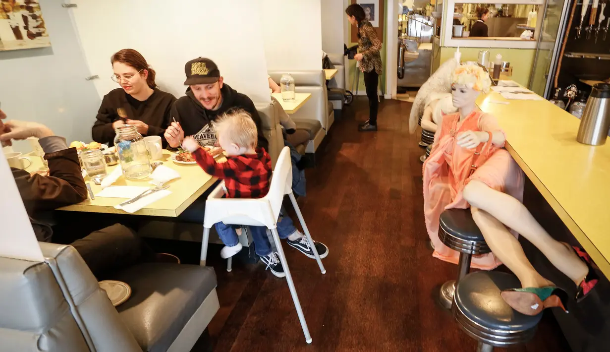 Manekin digunakan untuk menghalangi kursi di Roundel Cafe guna memberikan jarak fisik yang cukup bagi pelanggan di Vancouver, Kanada, pada 15 Juni 2020. Restoran Roundel Cafe menggunakan maneken alih-alih memberi pembatas pada kursi untuk membantu pelanggan menjaga jarak fisik. (Xinhua/Liang Sen)