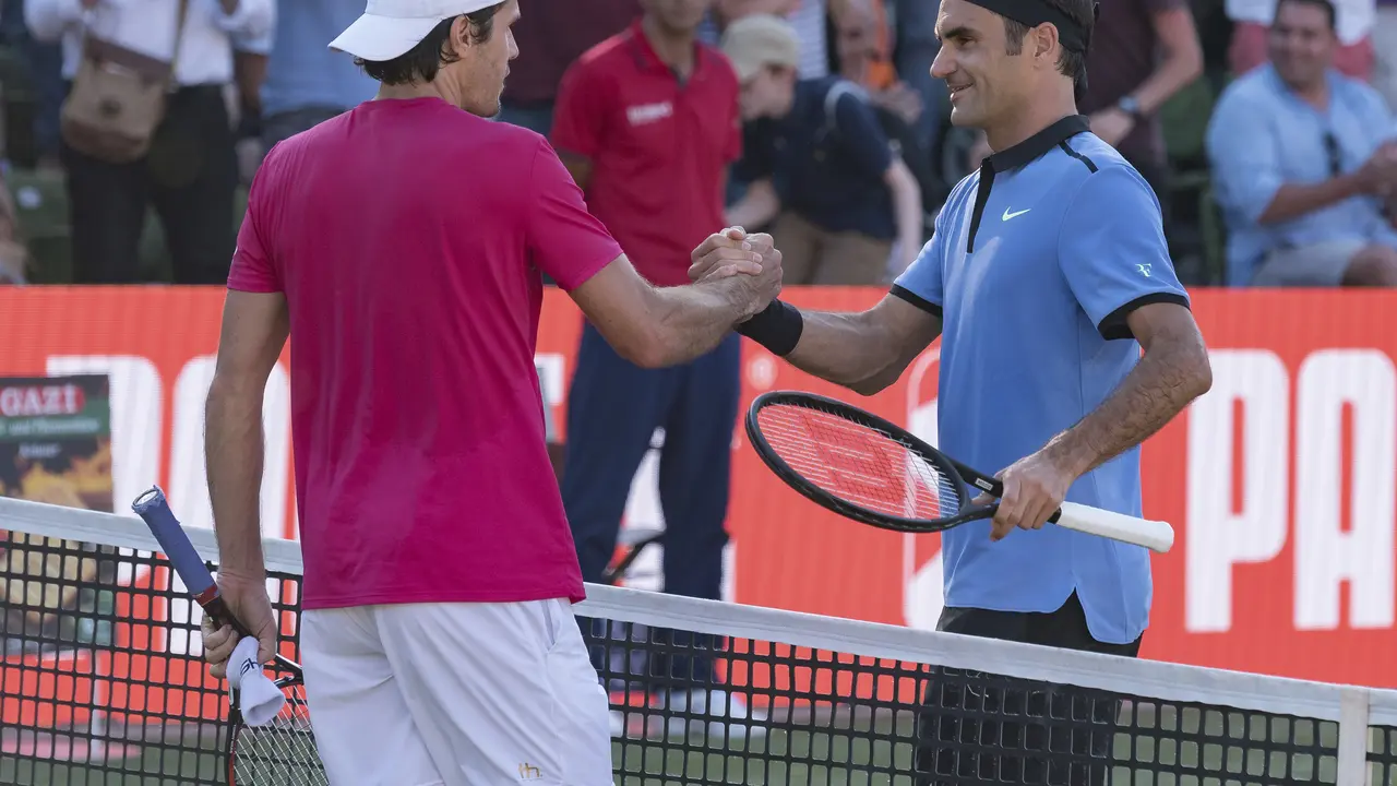 Roger Federer (kanan) memberi selamat kepada Tommy Haas yang mengalahkannya pada babak pertama Mercedes Cup, Rabu (14/6/2017). 