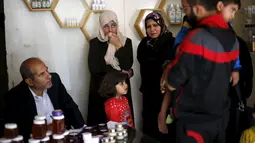 Rateb Samour (kiri) berbincang dengan pasiennya di klinik miliknya di Kota Gaza, 11 April 2016. Samour yang merupakan insinyur pertanian Palestina itu mewarisi keterampilan terapi sengatan lebah dari ayahnya (REUTERS/Suhaib Salem)