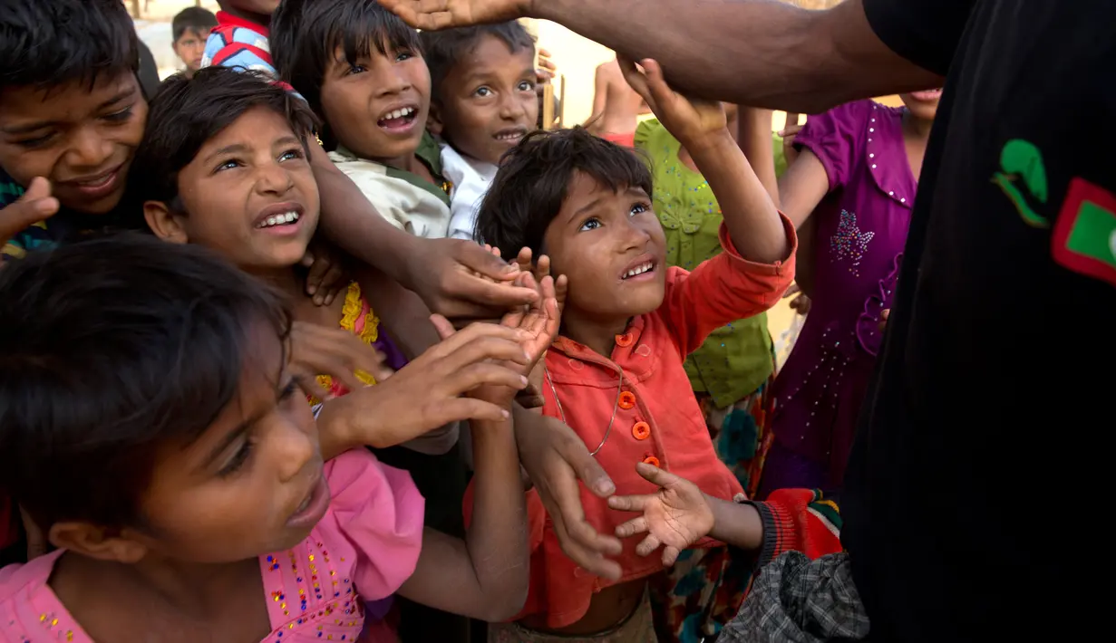 Anak-anak pengungsi Rohingya berdesakan berebut makanan di kamp pengungsi Balukhali, 50 kilometer dari Cox's Bazar, Bangladesh, Rabu (17/1). Sekitar 655.000 orang Rohingya telah melarikan diri ke Bangladesh sejak Agustus 2017. (AP Photo/Manish Swarup)
