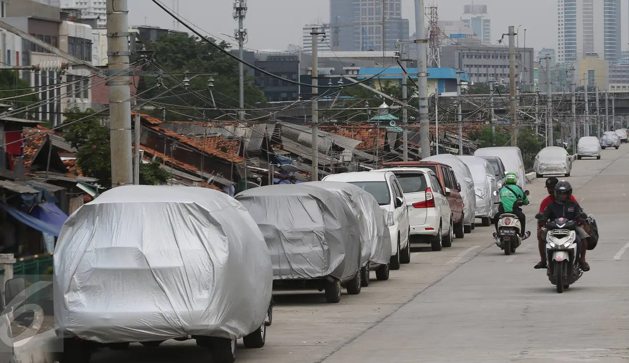 Pengendara motor melintas di jalur inspeksi Kanal Banjir Barat, Jakarta, Senin (6/3). Keterbatasan lahan menyebabkan sejumlah kendaraan parkir di tempat tersebut, meskipun telah terpampang larangan parkir. (Liputan6.com/Immanuel Antonius)