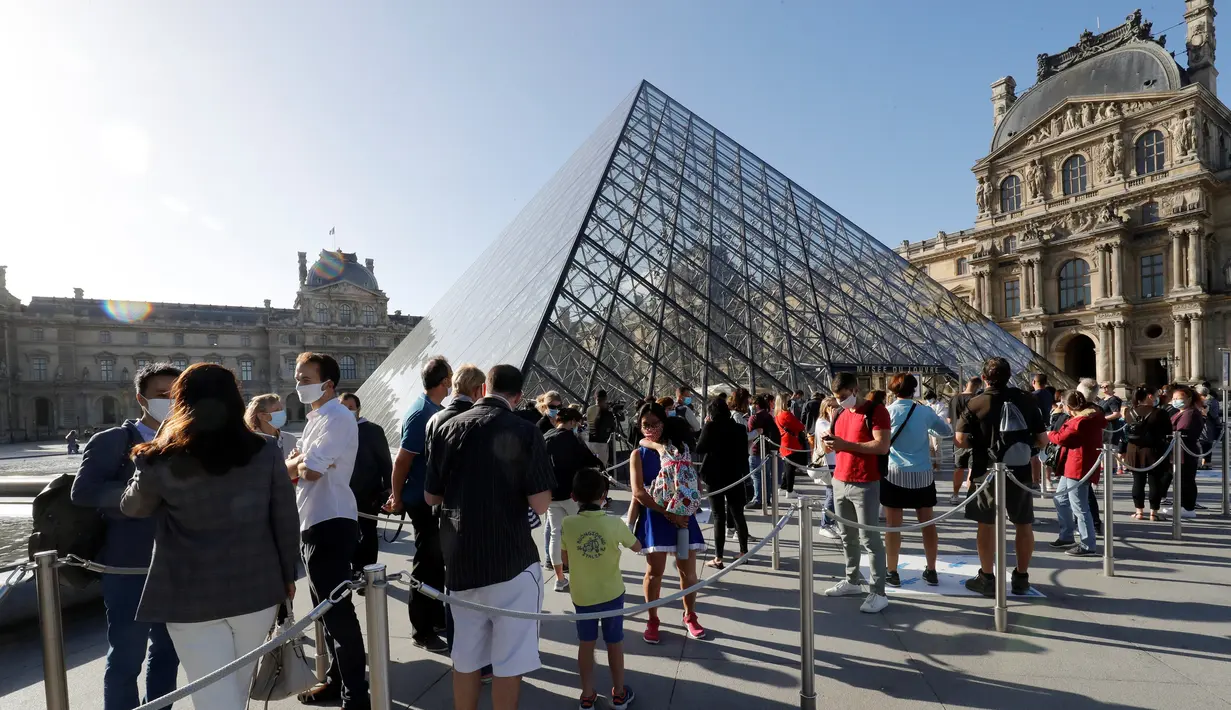 Pengunjung mengentre di piramida Louvre yang dirancang arsitek China Ieoh Ming Pei, pintu masuk ke Museum Louvre pada hari pertama pembukaan di Paris (6/7/2020). Setelah berbulan-bulan ditutup akibat lockdown Covid-19, Museum Louvre  kembali dibuka pada 6 Juli 2020. (AFP/Francois Guillot)