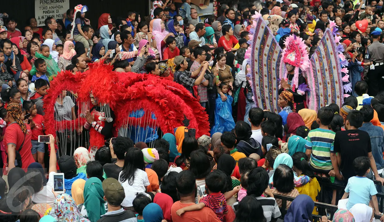 Peserta parade Pesta Rakyat Bogor melintas di tengah-tengah lautan massa yang memenuhi ruas Jalan Surya Kencana, Bogor, Senin (22/2/2016). Pesta Rakyat Bogor 2016 bersamaan dengan perayaan Cap Go Meh di Kota Bogor. (Liputan6.com/Helmi Fithriansyah)