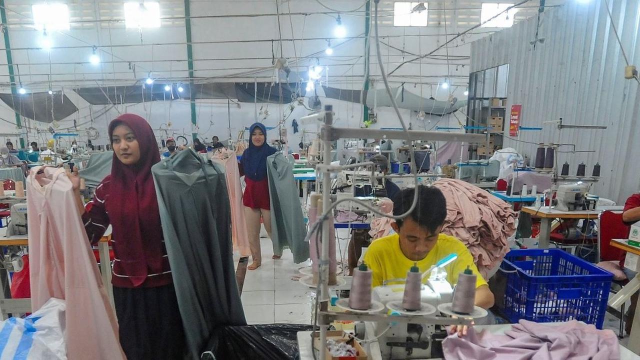Pekerja menyelesaikan pekerjaan terakhir pembuatan mukena  jelang libur hari Lebaran 2024 pada pabrik busana muslim Siti Khadijah di kawasan Limo, Depok, Jawa Barat, Kamis (04/04/2024). Foto: merdeka.com / Arie Basuki<br>