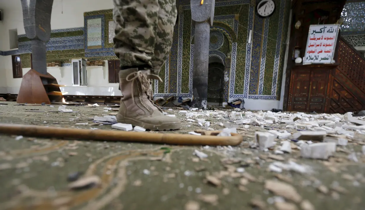 Seorang militan Houthi berdiri di dalam Masjid al-Balili, Yaman  pasca pemboman, Kamis (24/9/2015). Sebuah ledakan terjadi di Masjid Balili di Sanaa, Yaman. Dikabarkan, 29 orang tewas dan puluhan terluka. (REUTERS/Khaled Abdullah)