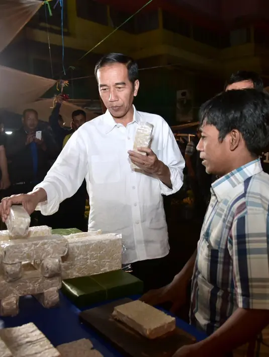 Presiden Joko Widodo (Jokowi) berbincang dengan pedagang tempe ketika blusukan ke Pasar Bogor, Jalan Roda, Kota Bogor, Selasa (30/10). Kepada para pedagang, Jokowi menanyakan kondisi harga komoditas yang mereka jual. (Liputan6.com/HO/Biro Pers Setpres)
