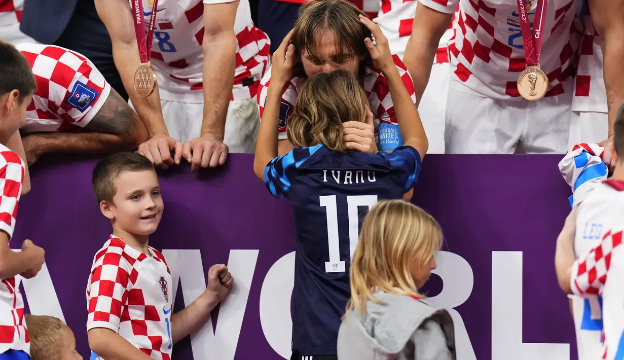 Gelandang Kroasia, Luka Modric mencium putranya Ivano setelah kemenangan melawan Maroko pada pertandingan playoff perebutan peringkat ketiga Piala Dunia 2022 di Khalifa International Stadium di Doha, Qatar, Sabtu (17/12/2022). Prestasi terbaiknya ialah mengantar Kroasia menjadi runner up Piala Dunia 2018 dan tahun ini. (AP Photo/Hassan Ammar)
