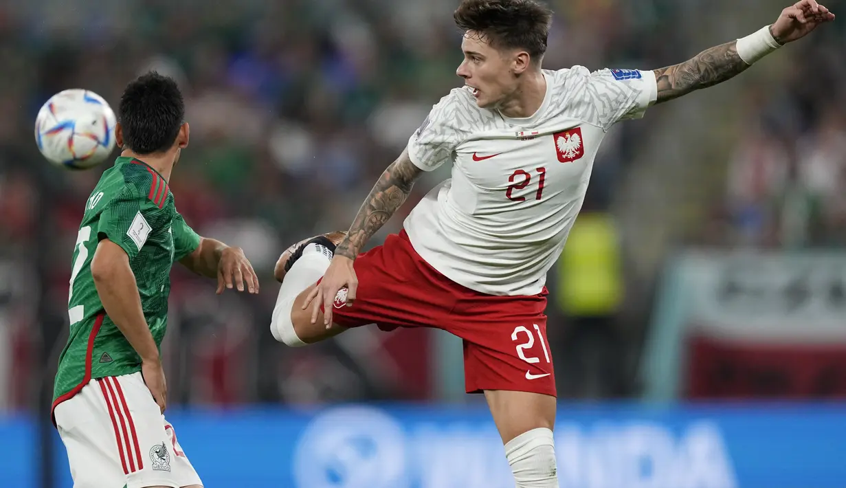 Penyerang Polandia, Nicola Zalewski berebut bola dengan pemain Meksiko, Hirving Lozano selama pertandingan grup C Piala Dunia 2022 Qatar di Stadion 974 di Doha, Qatar, Selasa (22/11/2022). Polandia bermain imbang dengan Meksiko dengan skor 0-0. (AP Photo/Martin Meissner)