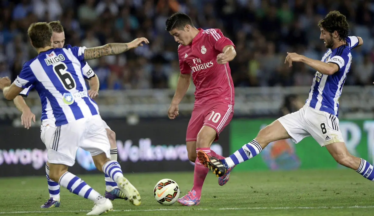 Penyerang Real Madrid, Karim Benzema (kiri), berusaha melewati hadangan tiga pemain Real Sociedad saat berlaga di lanjutan La Liga 2014-2015 di Stadion Anoeta, (1/9/2014). (REUTERS/Vincent West)