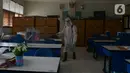 Petugas PMI menyemprotkan cairan disinfektan di Lingkungan SMP Negeri 139 Jakarta, Selasa (9/6/2020). Penyemprotan untuk mencegah penyebaran virus Corona di lingkungan sekolah itu sebagai persiapan memasuki tahun ajaran baru 2020/2021. (merdeka.com/Imam Buhori)