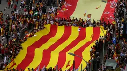 Sejumlah orang mengarak bendera Catalonia berukuran raksasa ketika merayakan Hari Nasional Spanyol di jalanan Barcelona, Kamis (12/10). Hari Nasional Spanyol merupakan peringatan tibanya Christopher Columbus di Amerika tahun 1492. (AP / Santi Palacios)