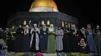 Muslim Palestina menjalani ibadah salat saat memburu malam Lailatul Qadar di luar Kubah Batu (Dome of the Rock) di kompleks Masjid Al-Aqsa di Yerusalem (8/5/2021). (AFP/Ahmad Gharabli)