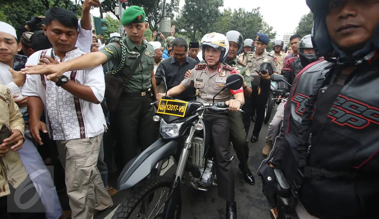 Kapolda Metro Jaya Irjen Pol Mochammad Iriawan bersama Mayor Jenderal TNI Teddy Lhaksmana mengendarai motor trail saat melintasi pengunjuk rasa di depan gedung Balaikota DKI Jakarta, Jumat (14/10). (Liputan6.com/Immanuel Antonius)