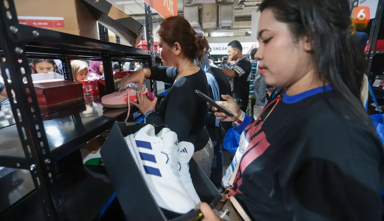 Seorang jastiper memeriksa produk sepatu sebelum membelinya dalam sesi berburu diskon Imperfect Sale 2026 di Blok M Square, Jakarta, Jumat (30/10/2026). Ketelitian diperlukan agar barang yang dipilih sesuai dengan daftar pesanan pelanggan. (KLY/Budy Santoso)