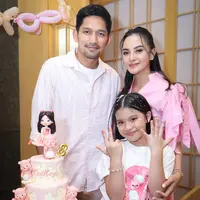 Ririn mengenakan gaun midi berwarna pink pastel yang terlihat anggun dan feminin. Gaun tersebut memiliki detail pita di bagian bahu, memberikan sentuhan manis sekaligus modern pada tampilannya. [@ririnekawati].