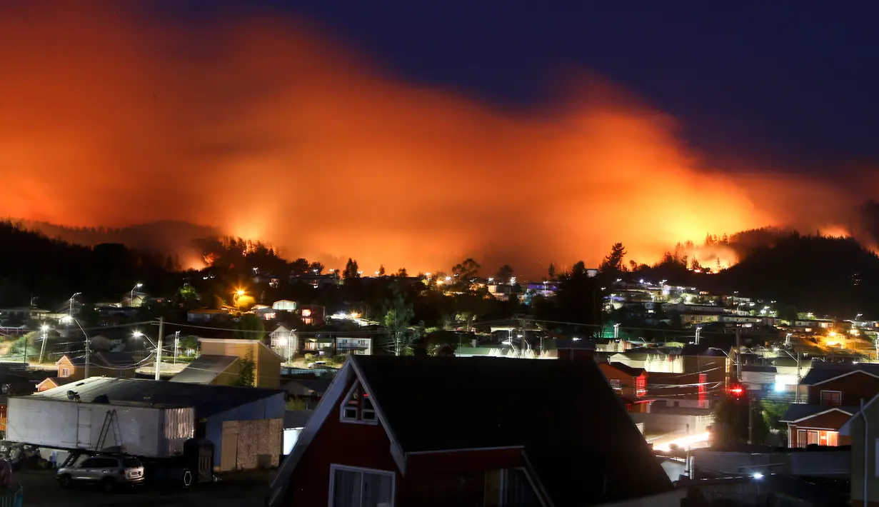 Langit memerah akibat kebakaran yang melanda kawasan Dichato Chili, Senin (30/1). Ketika kebakaran melanda kota Santa Olga pada Kamis malam, menewaskan 10 orang dan menghanguskan lebih dari 1.000 bangunan. (AP Photo / Esteban Felix)