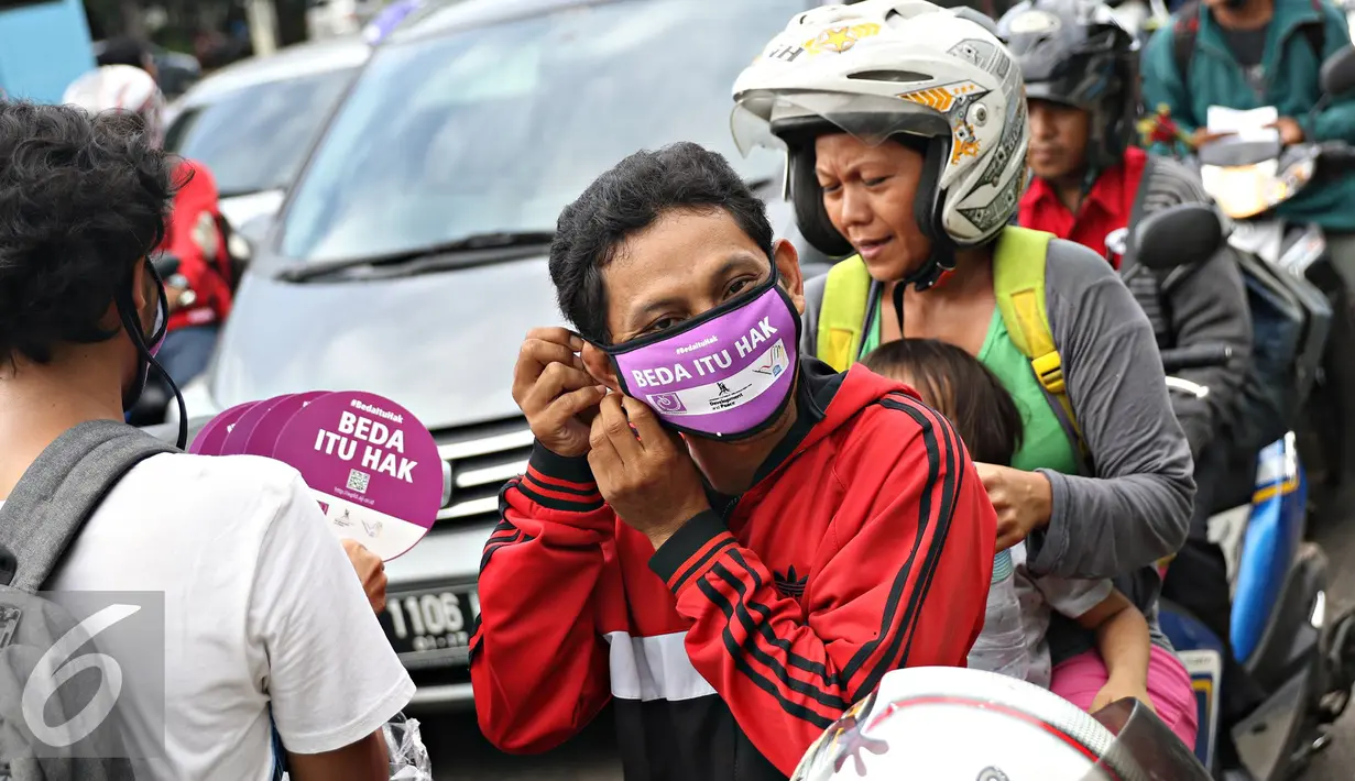 Pengendara motor memakai masker saat aksi damai dengan membagikan masker dan kipas kepada pengendara di Jakarta, Selasa (3/5). AJI juga menyatakan bahwa musuh kebebasan pers 2016 adalah kepolisian. (Liputan6.com/Immanuel Antonius)