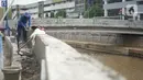 Petugas menyelesaikan proyek peninggian turap Anak Sungai Ciliwung di kawasan Senen, Jakarta, Rabu (4/11/2020). Peninggian turap dilakukan sebagai langkah mengantisipasi banjir yang berasal dari luapan aliran sungai saat hujan deras. (Liputan6.com/Immanuel Antonius)