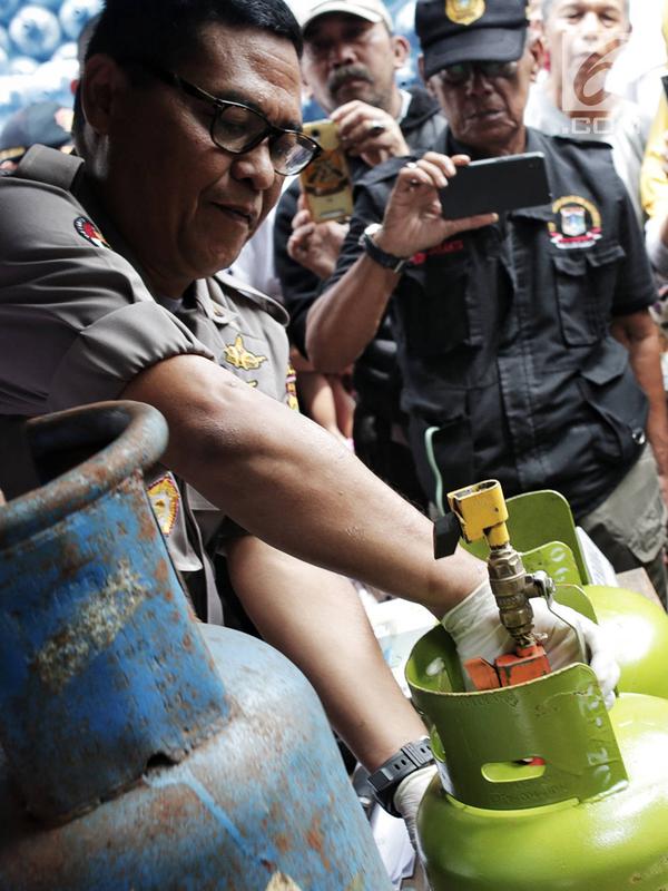 Kabid Humas Polda Metro Jaya Kombes Pol Argo Yuwono menunjukkan proses penyuntikan tabung gas di Cipayung, Jakarta, Selasa (22/1). Subdit III Sumdaling Ditreskrimsus Polda Metro Jaya membekuk empat tersangka dalam kasus ini. (Liputan6.com/Faizal Fanani)