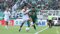 Duel pemain Persebaya, Reva Adi Utama (kanan) dengan penyerang Arema, Dendi Santoso dalam laga BRI Liga 1 2023/2024 di Stadion Gelora Bung Tomo, Surabaya, Sabtu (23/9/2023). (Bola.com/Aditya Wany)