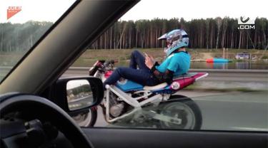 Rekaman video seorang pria mengendarai sepeda motor tanpa memegang setang. Ia berjalan dengan kecepatan 80 km/jam.