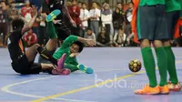 Pemain Timnas Futsal Indonesia, Ardy Dwi terjatuh saat berebut bola dengan pemain Blacksteel Manokwari pada laga uji coba jelang AFF Championship 2017 Thailand di Tifosi Sport Center, Selasa (16/1/2016). Timnas menang 8-6. (Bola.com/Nicklas Hanoatubun)