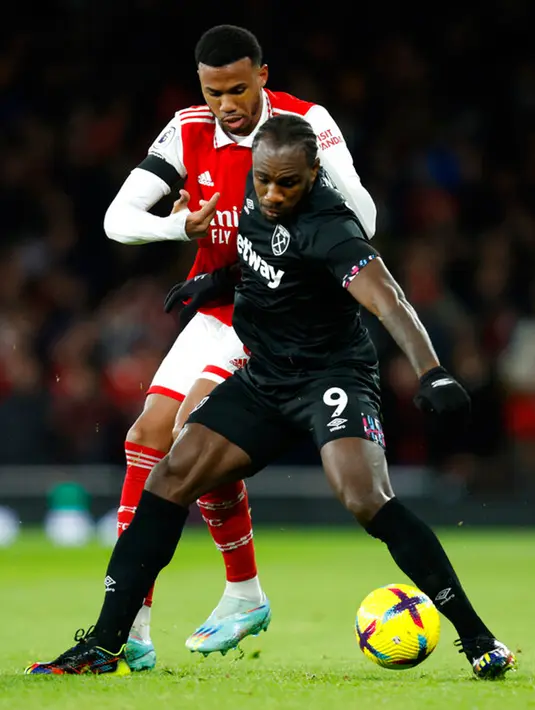 Pemain West Ham United Michail Antonio (depan) berduel memperebutkan bola dengan pemain Arsenal Gabriel pada pertandingan sepak bola Liga Inggris di Emirates Stadium, London, Inggris, 26 Desember 2022. Arsenal mengalahkan West Ham United dengan skor 3-1. (AP Photo/David Cliff)