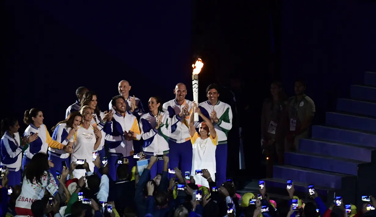 Vanderlei Cordeiro de Lima bersama para pembawa obor bersiap untuk menyalakan kaldron Olimpiade 2016  di Stadion Maracana di Rio de Janeiro, (5/8). Pria 46 tahun tersebut menggantikan Pele, yang batal hadir karena sakit. (AFP PHOTO/Fabrice COFFRINI)