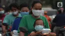 Warga menerima pembagian nasi bungkus gratis di Posko Perjuangan Rakyat (POSPERA), Jakarta, Rabu (10/3/2021). Pembagian 500 nasi bungkus beserta masker dan vitamin secara gratis setiap harinya dalam bentuk meringankan beban warga di tengah pandemi Covid-19. (merdeka.com/Imam Buhori)