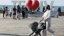 Seorang perempuan mendorong kereta bayi saat menikmati hari yang cerah di Tel Aviv, Israel, pada 26 Desember 2020. Karantina wilayah (lockdown) penuh ketiga akan diberlakukan secara nasional di Israel mulai Minggu (27/12) pukul 17.00 waktu setempat. (Xinhua/JINI/Gideon Markowicz)