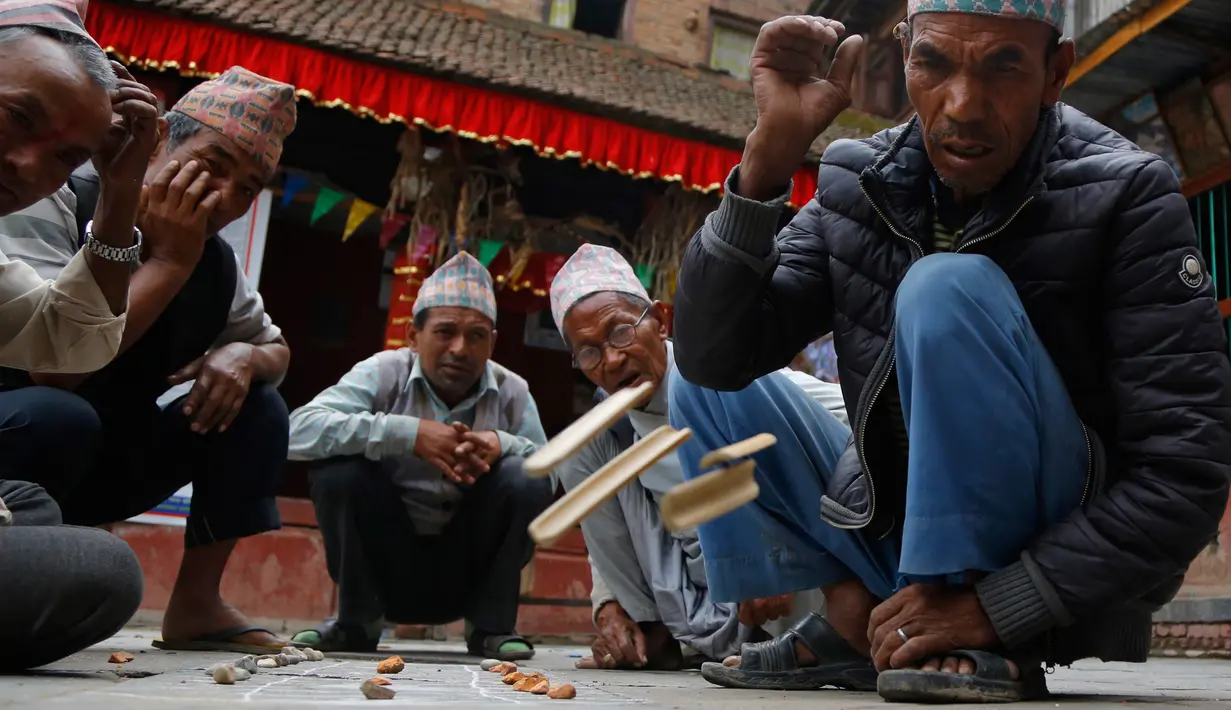 Lansia Nepal melempar bambu saat memainkan permainan tradisional Kashi Pyachha di Bhaktapur, Nepal (30/5). Permainan ini hampir hampir punah dan hanya populer di kalangan generasi yang lebih tua di Nepal. (AP/Niranjan Shrestha)