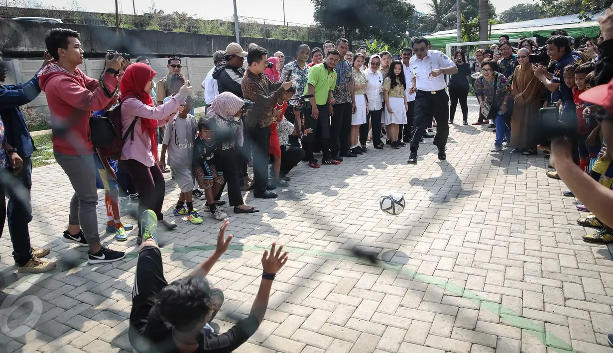 Gubernur DKI Basuki Tjahaja Purnama (Ahok) ketika bermain bola dengan seorang anak usai meresmikan RPTRA Tahap II Provinsi DKI Jakarta, di Jalan Pluit Mas Utara, Kelurahan Pejagalan, Kecamatan Penjaringan, Jakarta, Rabu (6/4). (Liputan6.com/Faizal Fanani)