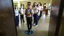 Para siswa menunggu instruksi untuk masuk ruang kelas pada hari pertama kembali ke kelas tatap muka sejak dimulainya pembatasan pandemi COVID-19 di sebuah sekolah umum di Caracas, Venezuela, 25 Oktober 2021. (AP Photo/Ariana Cubillos)