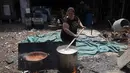 Rosana Sanchez menyiapkan makanan untuk tetangga dan orang-orang yang bekerja di daur ulang, di tempat makan malam populer yang disebut "Cartoneritos," di pinggiran Buenos Aires, Argentina (14/12/2021). Angka kemiskinan mencapai 40,6 persen pada paruh pertama tahun 2021. (AP Photo/Rodrigo Abd)