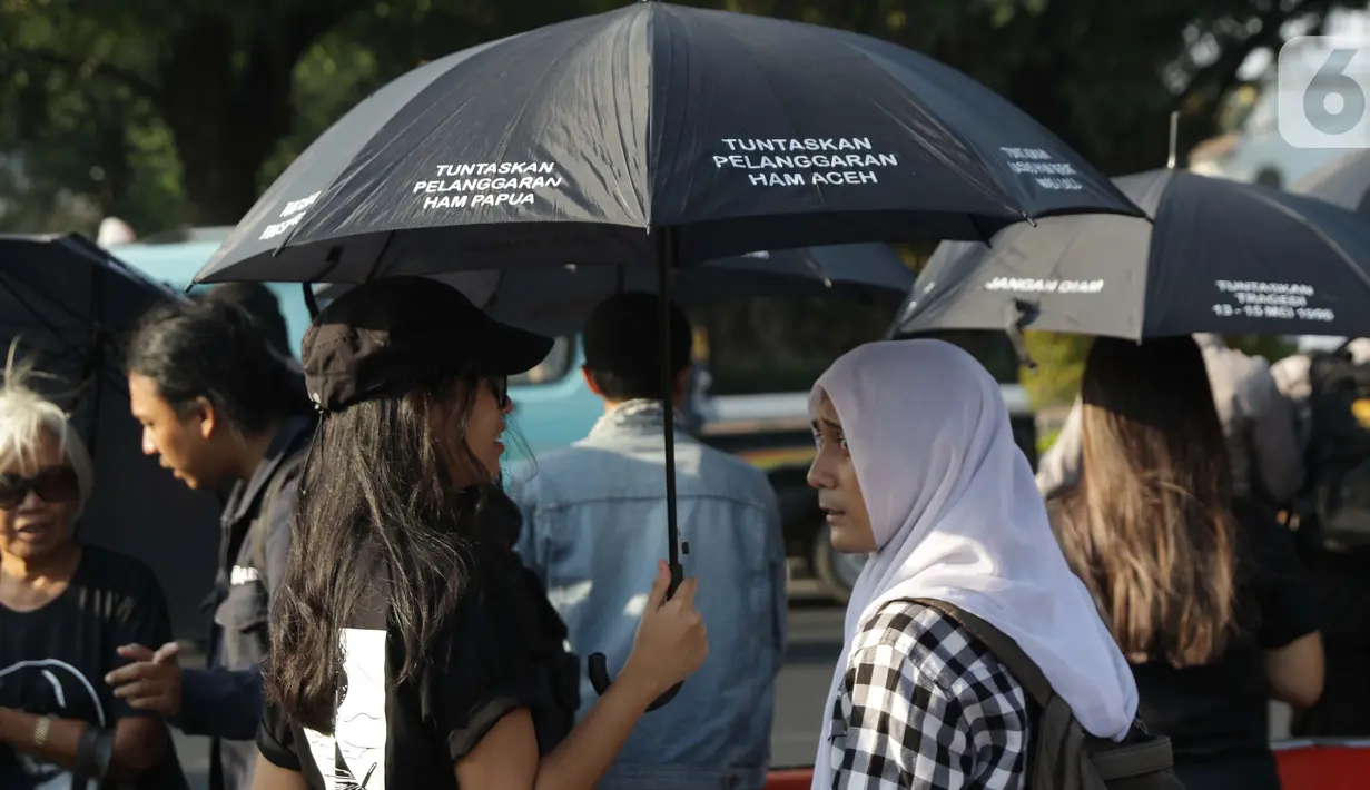 Aktivis saat melakukan Aksi Kamisan ke-604 di depan Istana Merdeka, Jakarta, Kamis (3/9/2019). Aksi Kamisan ke-604 mendesak pemerintah menuntaskan beragam kasus pelanggaran HAM masa lalu, selain itu mereka juga berdiskusi tentang #reformasidikorupsi. (Liputan6.com/Helmi Fithriansyah)