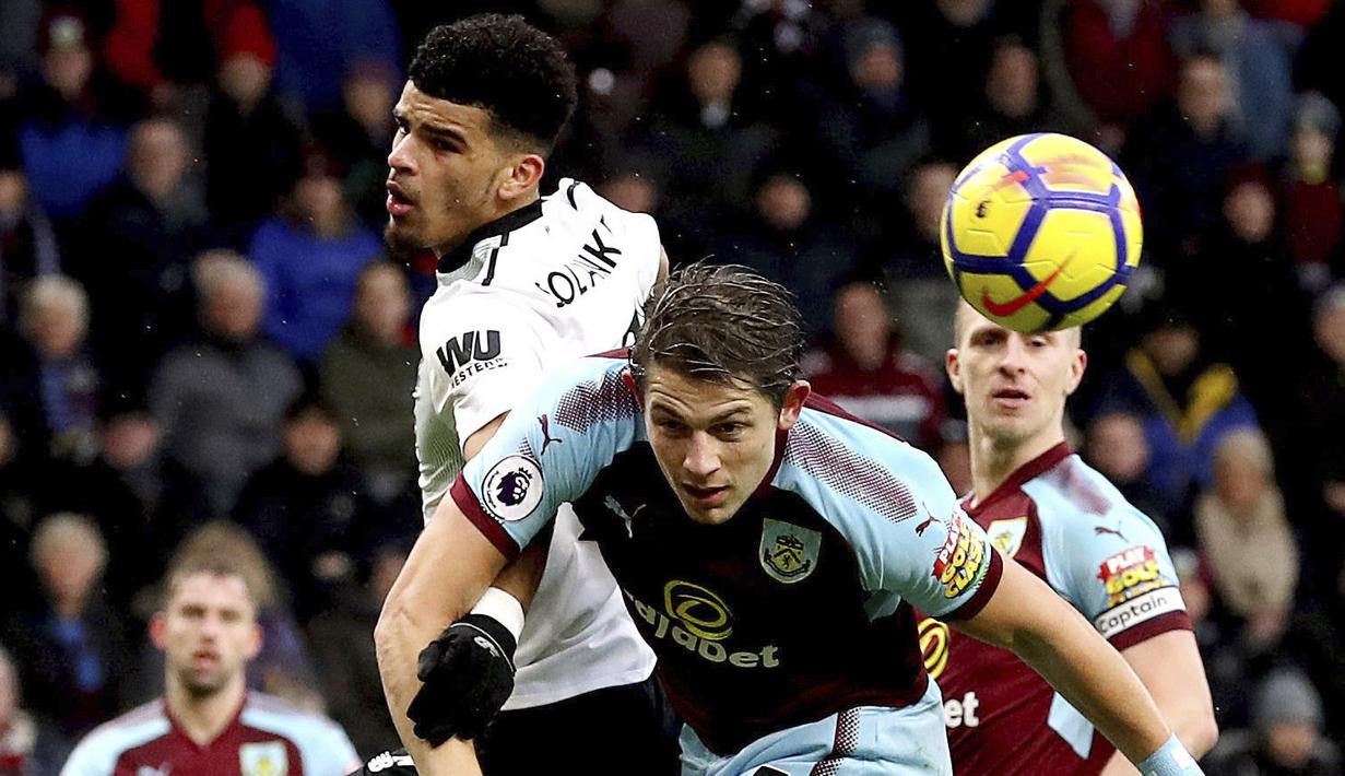 Pemain Liverpool, Dominic Solanke (kiri) dan pemain Burnley, James Tarkowski berebut bola pada lanjutan Premier League di Turf Moor, Burnley, (1/1/2018). Liverpool menang 2-1 atas Burnley. (Martin Rickett/PA via AP)