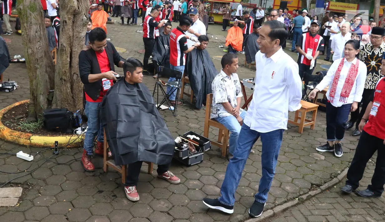 Presiden Joko Widodo melihat warga mengikuti acara cukur rambut massal di Garut, Jawa Barat, Sabtu (19/1). Dalam acara cukur rambut massal ini, rambut Jokowi dicukur oleh tukang cukur langganannya, Herman. (Liputan6.com/Angga Yuniar)