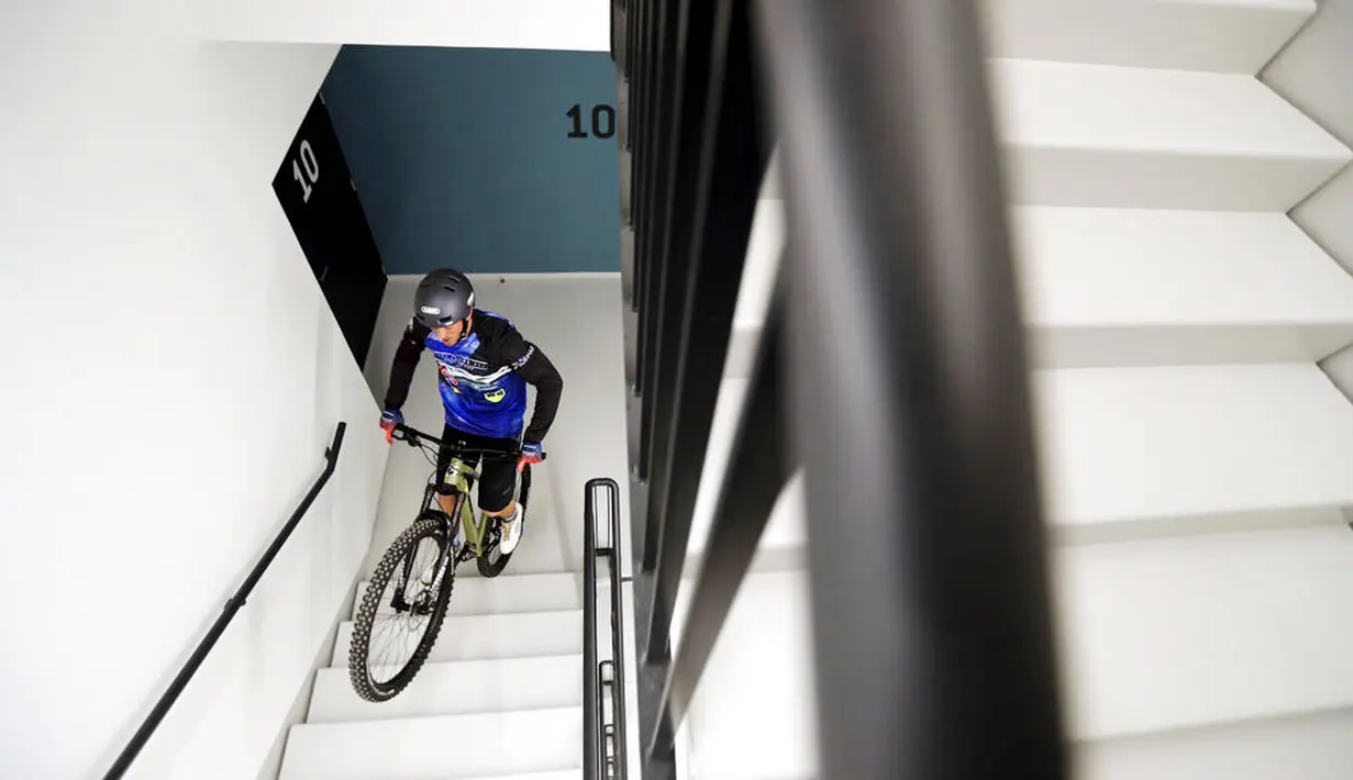 Pembalap sepeda asal Prancis, Aurelien Fontenoy, saat mendaki 768 anak tangga dari 33 lantai gedung Trinity Tower di distrik La Defense, Paris, (17/1/2021). (AP/Christophe Ena)