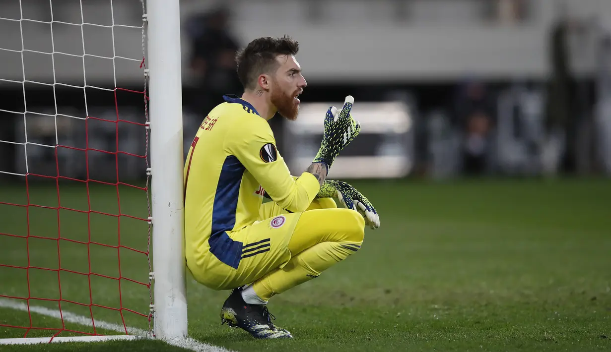 Kiper Olympiakos, Jose Sa memberi instruksi kepada rekan-rekannya saat menghadapi Arsenal dalam laga leg pertama babak 16 besar Liga Europa 2020/2021 di Georgios Karaiskakis Stadium, Kamis (11/3/2021). Olympiakos kalah 1-3 dari Arsenal. (AP/Thanassis Stavrakis)