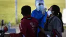 Seorang petugas kesehatan mengambil sampel usap hidung dari seorang pria untuk tes COVID secara gratis di tempat pengujian drive-thru di arena pacuan kuda di Capiata, Paraguay, Selasa (11/1/2022).  (AP Photo/Jorge Saenz)