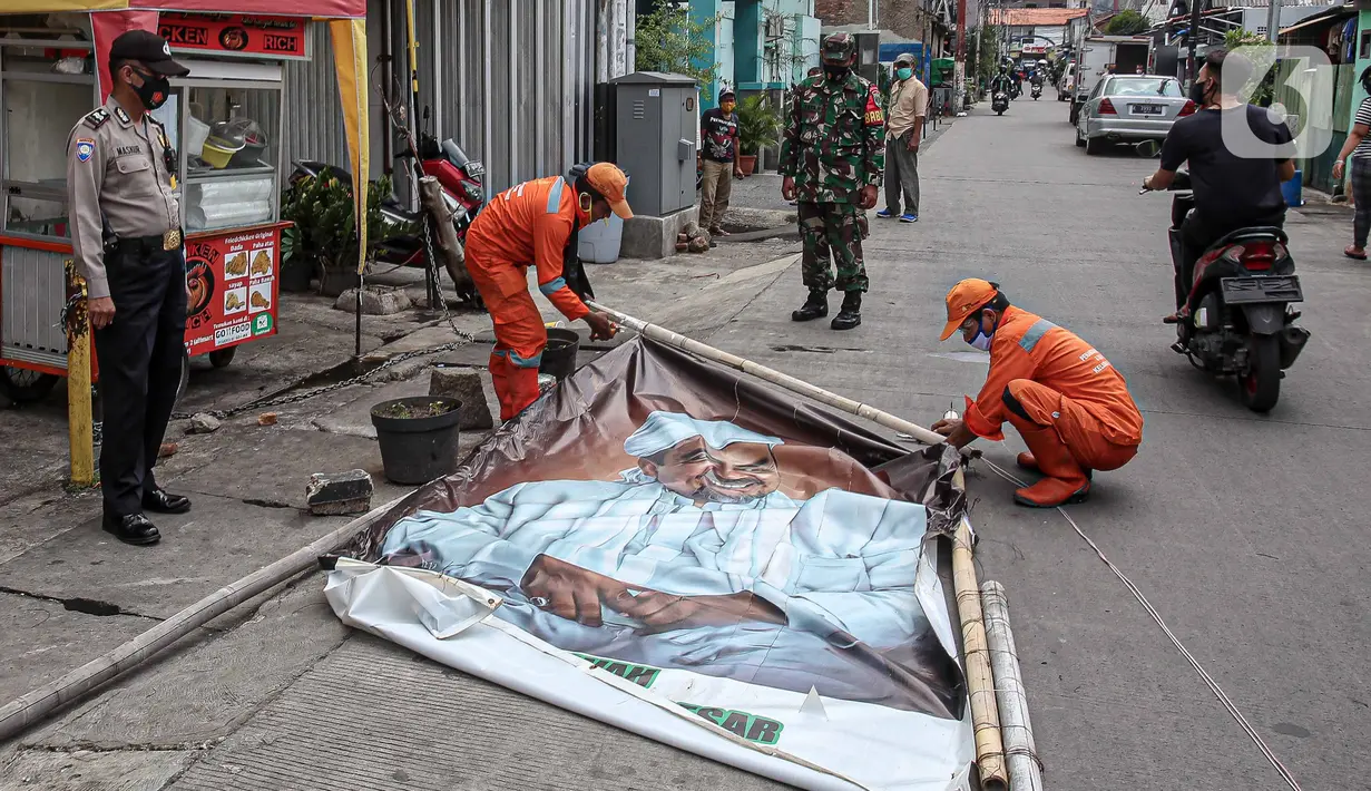 Petugas PPSU didampingi TNI dan Polri mencopot baliho Rizieq Shihab di Kawasan Kramat Pulo Dalam Senen, Jakarta, Rabu (25/11/2020). Pihak kelurahan, TNI dan Polri terus berupaya menurunkan baliho dan spanduk yang tidak berizin, termasuk salah satunya baliho Rizieq Shihab (Liputan6.com/Faizal Fanani)