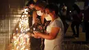 Orang-orang menyalakan lilin untuk mengenang mereka yang meninggal akibat virus corona di depan Kementerian Kesehatan di Asuncion, Paraguay, Minggu (14/3/2021). Sejauh ini, Paraguay mencatat 3.450 kasus kematian akibat COVID-19. (AP Photo/Jorge Saenz)