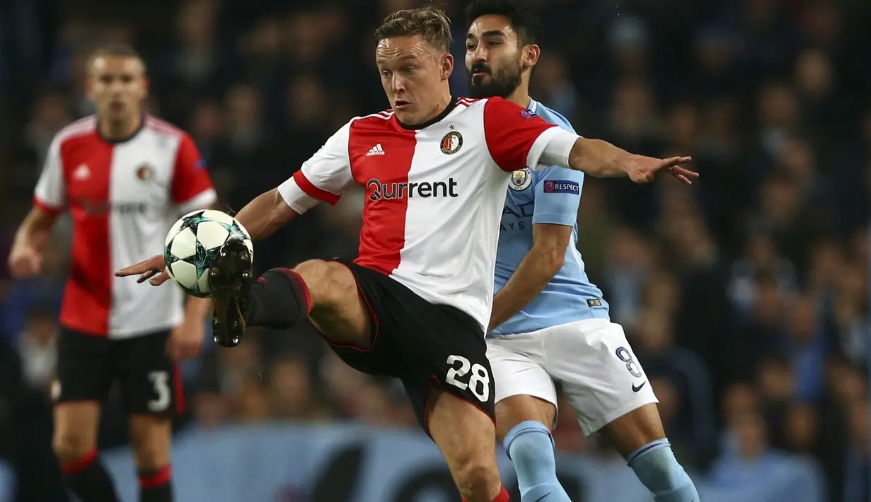 Pemain Feyenoord, Jens Toornstra (kiri) menghalau bola dari kejaran pemain Manchester City, Ilkay Gundogan pada laga group F Liga Champions di Etihad Stadium, Manchester, (21/11/2017). City menang 1-0. (AP/Dave Thompson)