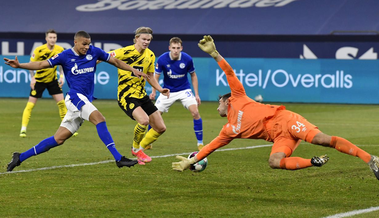 Striker Borussia Dortmund, Erling Haaland (tengah) mencetak gol keempat timnya ke gawang Schalke dalam laga lanjutan Liga Jerman 2020/21 pekan ke-22 di Veltins Arena, Sabtu (20/2/2021). Borussia Dortmund menang 4-0 atas Schalke. (AP/Martin Meissner/Pool)