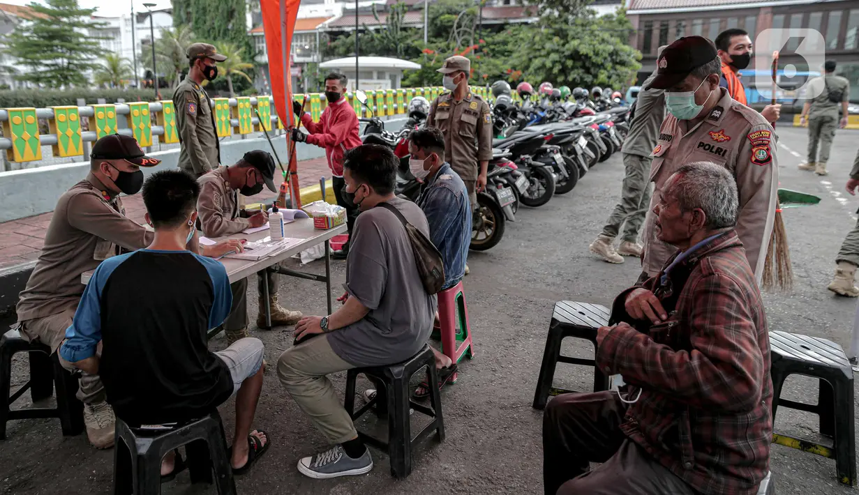 Petugas Satpol PP berrsama polisi mendata warga saat razia masker di kawasan Kota Tua, Jakarta, Kamis (24/2/2022). Perpanjangan PPKM level 3 Jabodetabek tertuang dalam Instruksi Menteri Dalam Negeri No. 12 Tahun 2022 tentang PPKM level 4, 3, 2 di Jawa dan Bali. (Liputan6.com/Faizal Fanani)