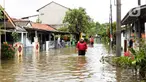 Warga melintasi genangan air di salah satu permukiman di kawasan Cakung, Jakarta Timur, Rabu (29/1/2025). (Liputan6.com/Herman Zakharia)