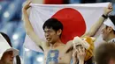 Suporter Jepang menangis sambil membentangkan bendera negara pertandingan melawan Belgia pada babak 16 besar Piala Dunia 2018 di Rostov Arena, di Rostov-on-Don, Rusia, (2/7). Jepang takluk dengan dramatis atas Rusia 3-2. (AP Photo / Petr David Josek)