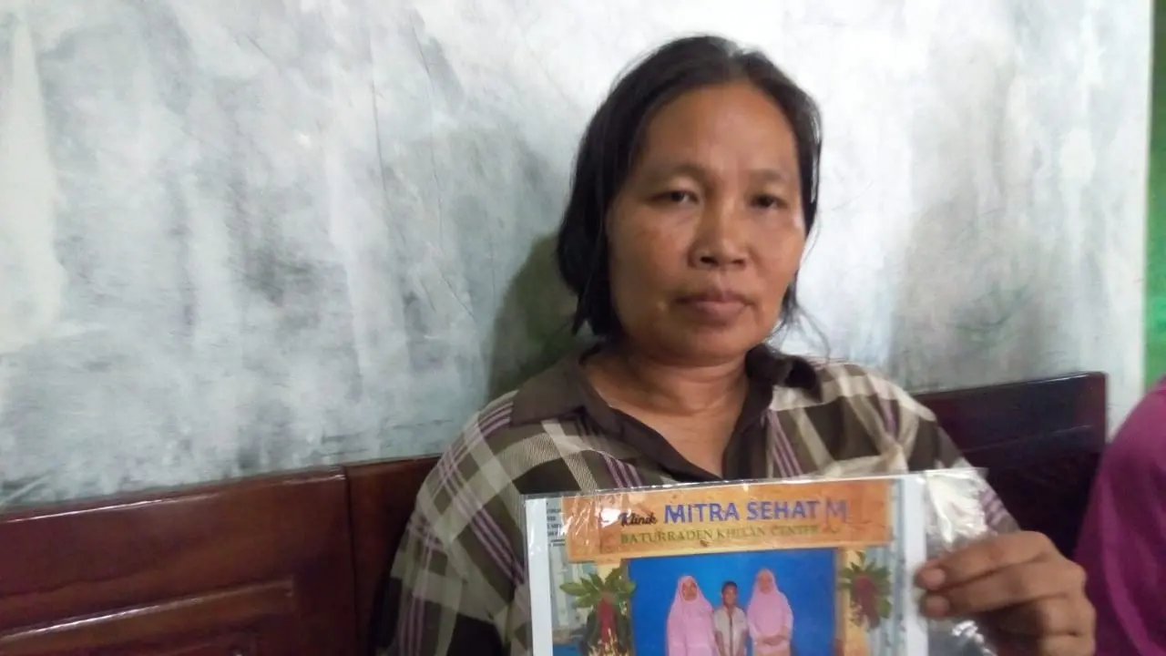 Sulastri, ibu Dwi Nur Fauzi, pemuda yang meninggal akibat demam berdarah di Kutasari, Purbalingga, menunjukkan foto bersama Dwi di rumahnya, Kamis (27/2). Ada 12 warga Kutasari yang terserang demam berdarah. (Foto: Liputan6.com/Rudal Afgani Dirgantara)