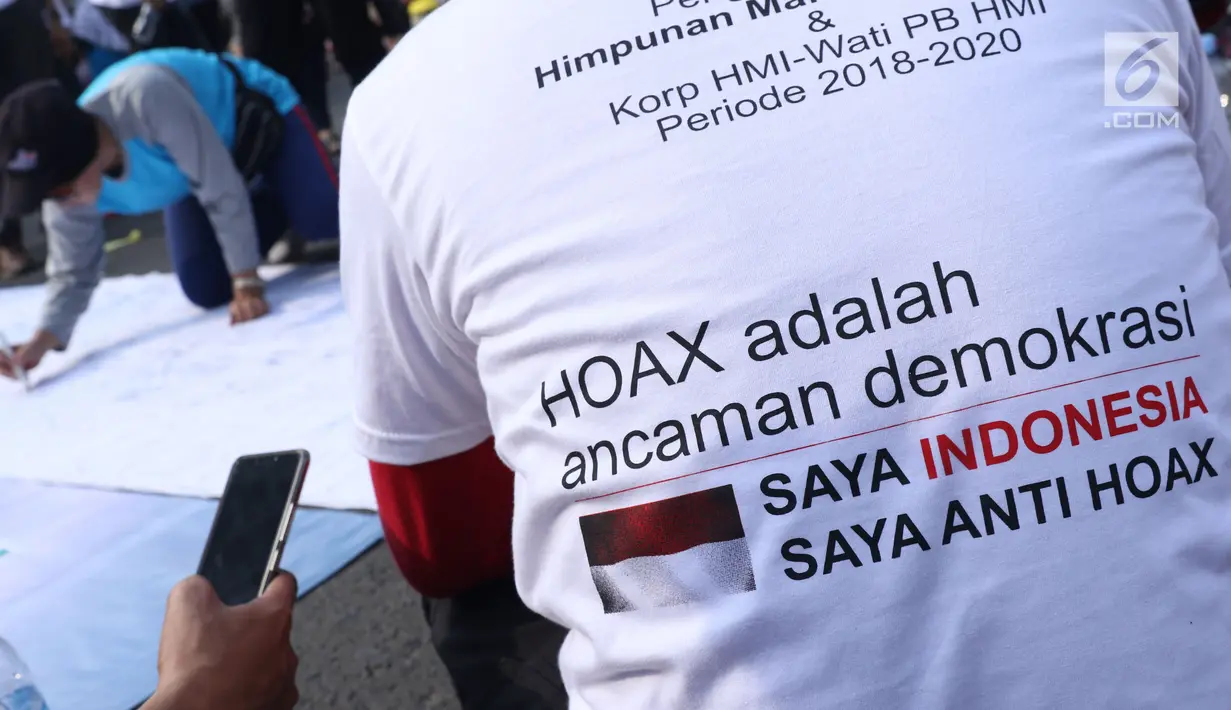 Salah satu pengurus PB HMI melihat warga yang menandatangani spanduk dukungan anti hoax di kawasan Bundaran Hotel Indonesia, Jakarta, Minggu (18/11). PB HMI mensosialisasikan Hoax sebagai ancaman demokrasi di Indonesia. (Liputan6.com/Helmi Fithriansyah)